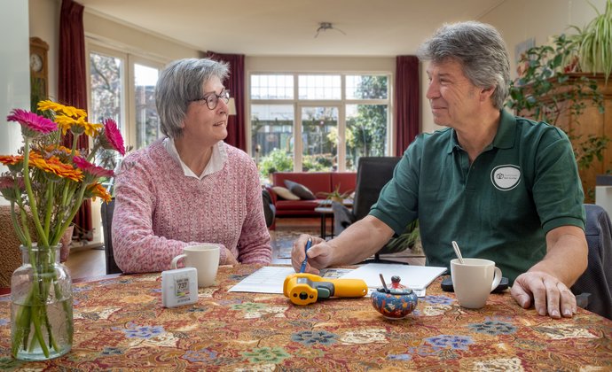 Toos zit thuis aan tafel met de energiecoach