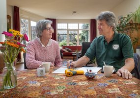 Toos zit thuis aan tafel met de energiecoach